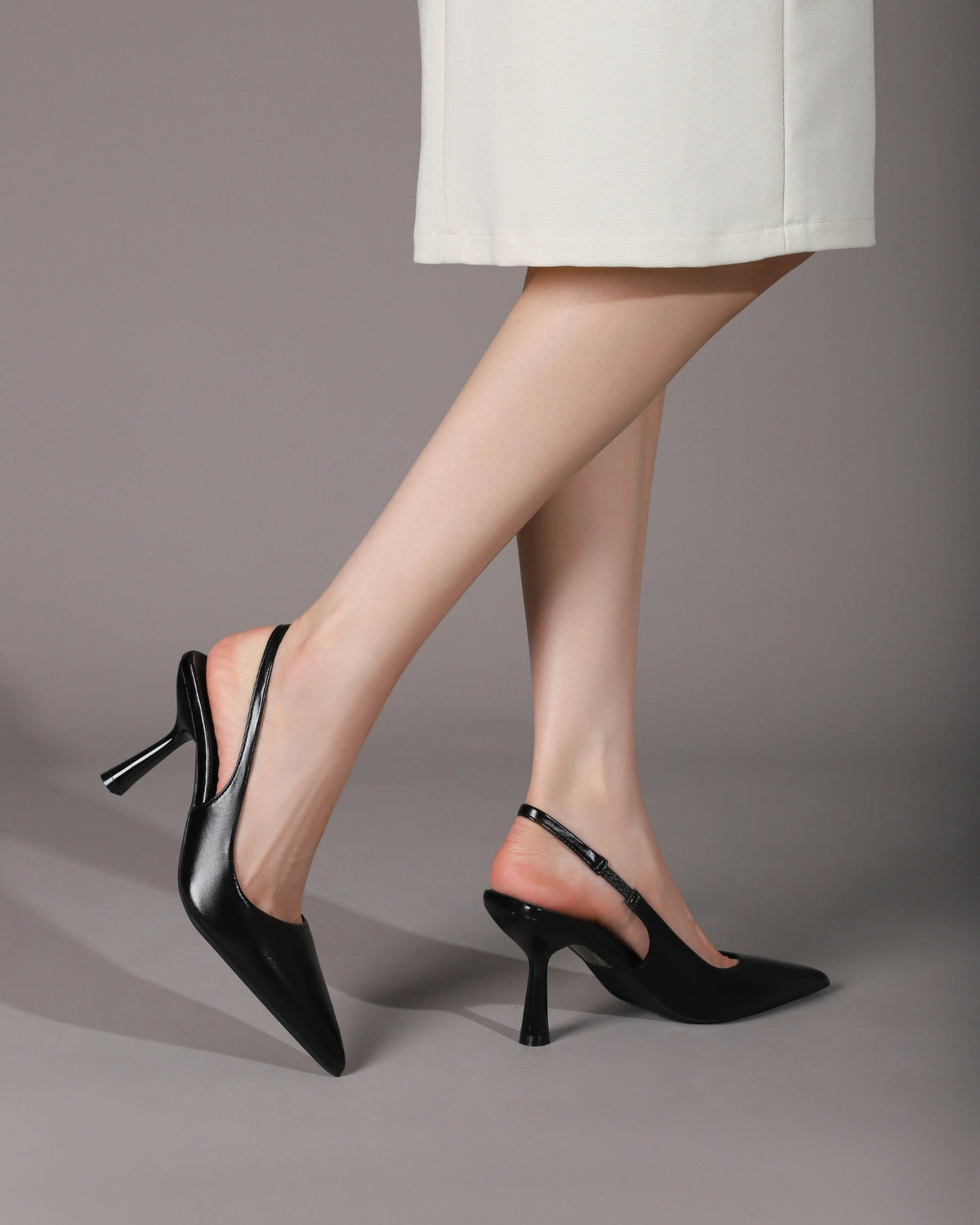 Black pointed-toe heels side on-foot view