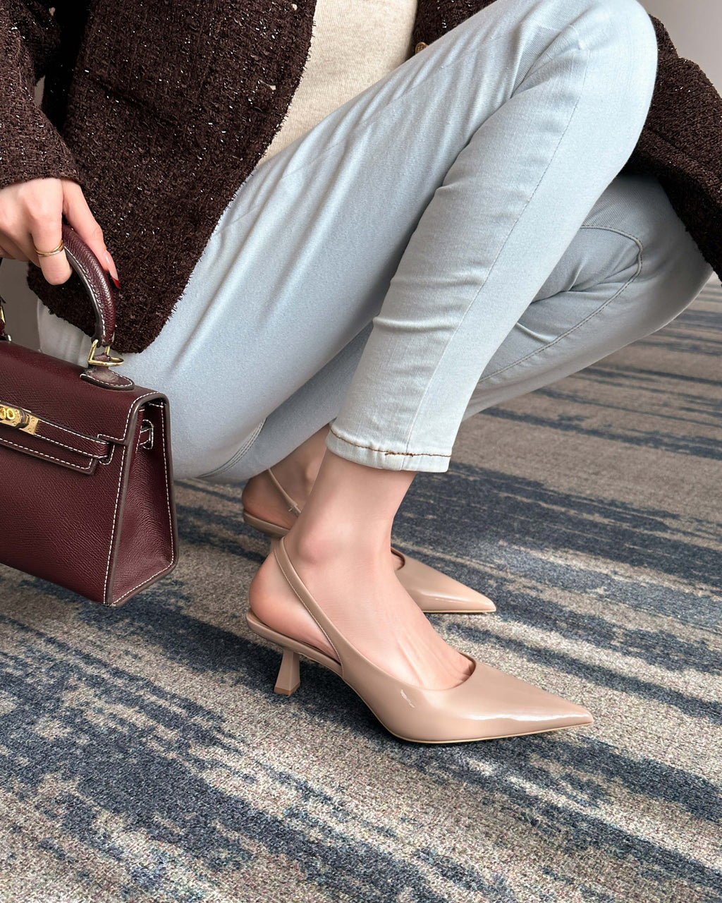 Khaki pointed-toe patent slingback pumps on foot