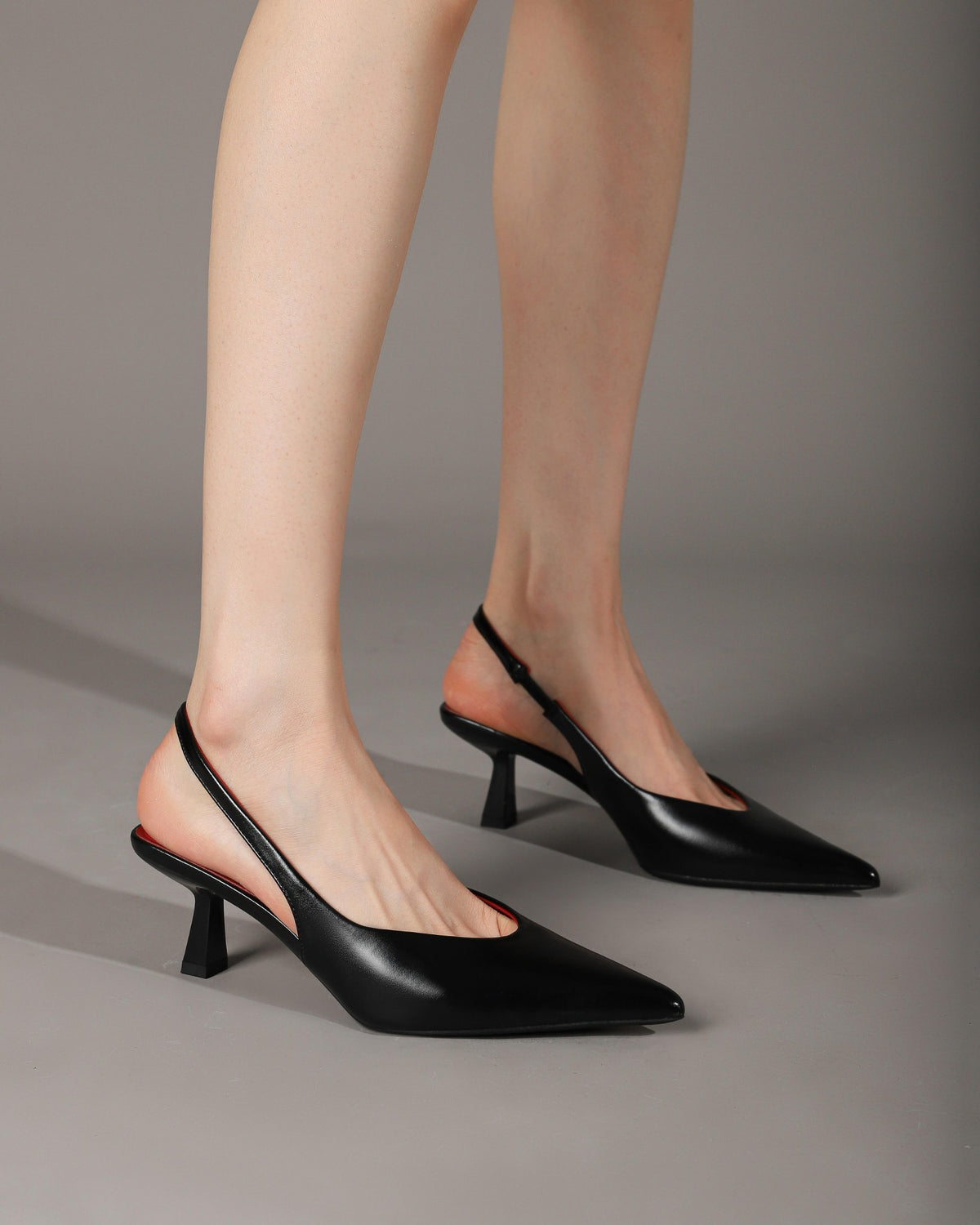 Black slingback heels modeled side view