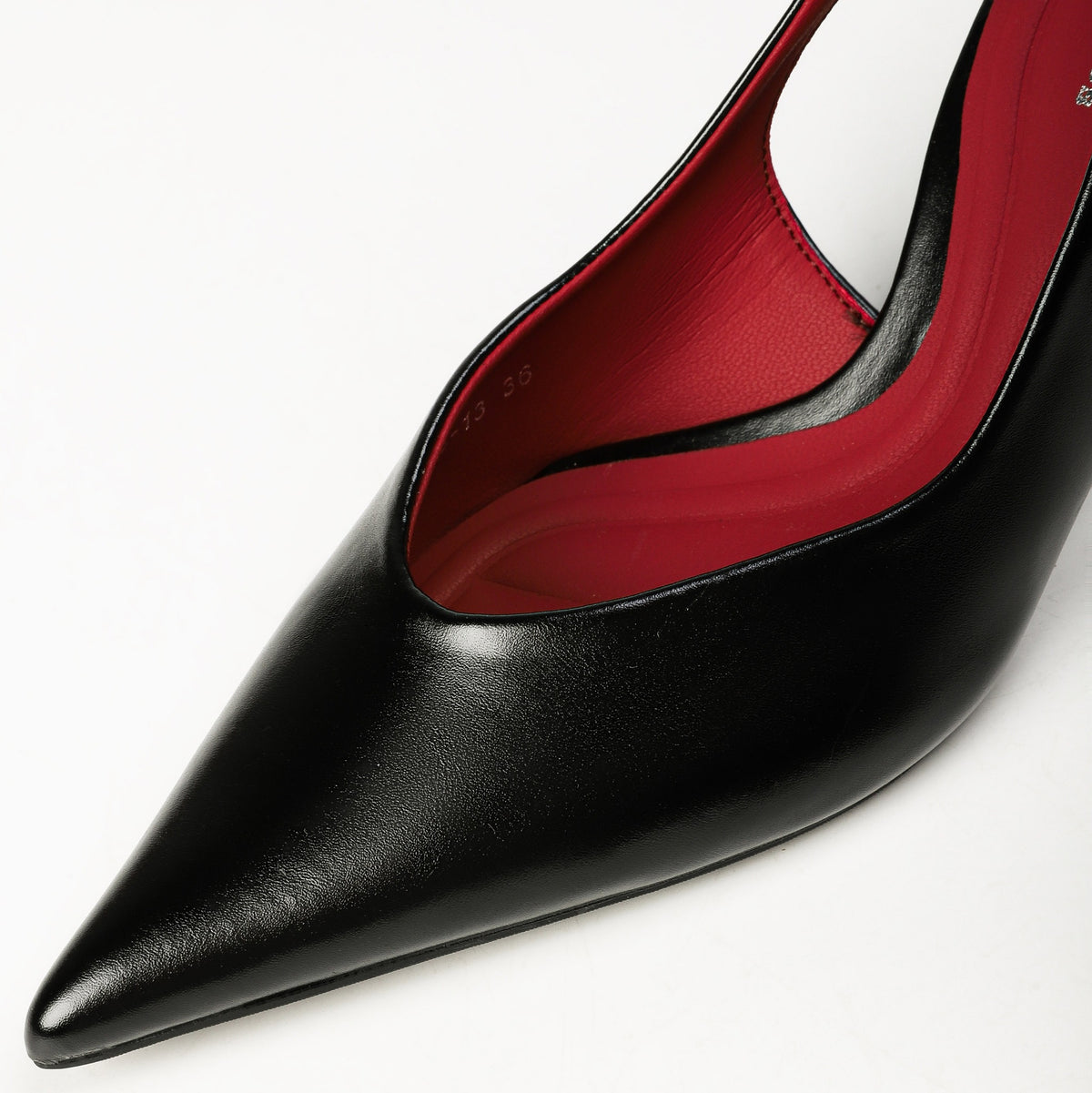Black pointed-toe upper material and red lining close-up