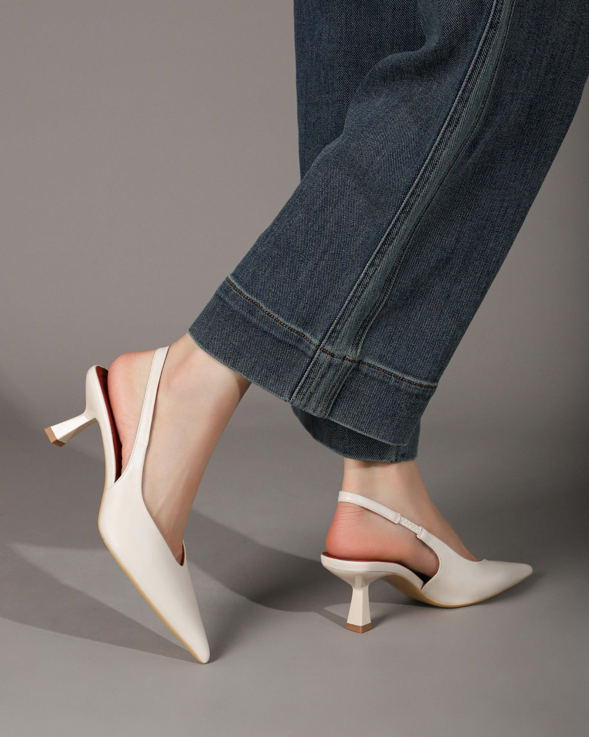 Off-white pointed-toe slingback heels modeled side and rear view