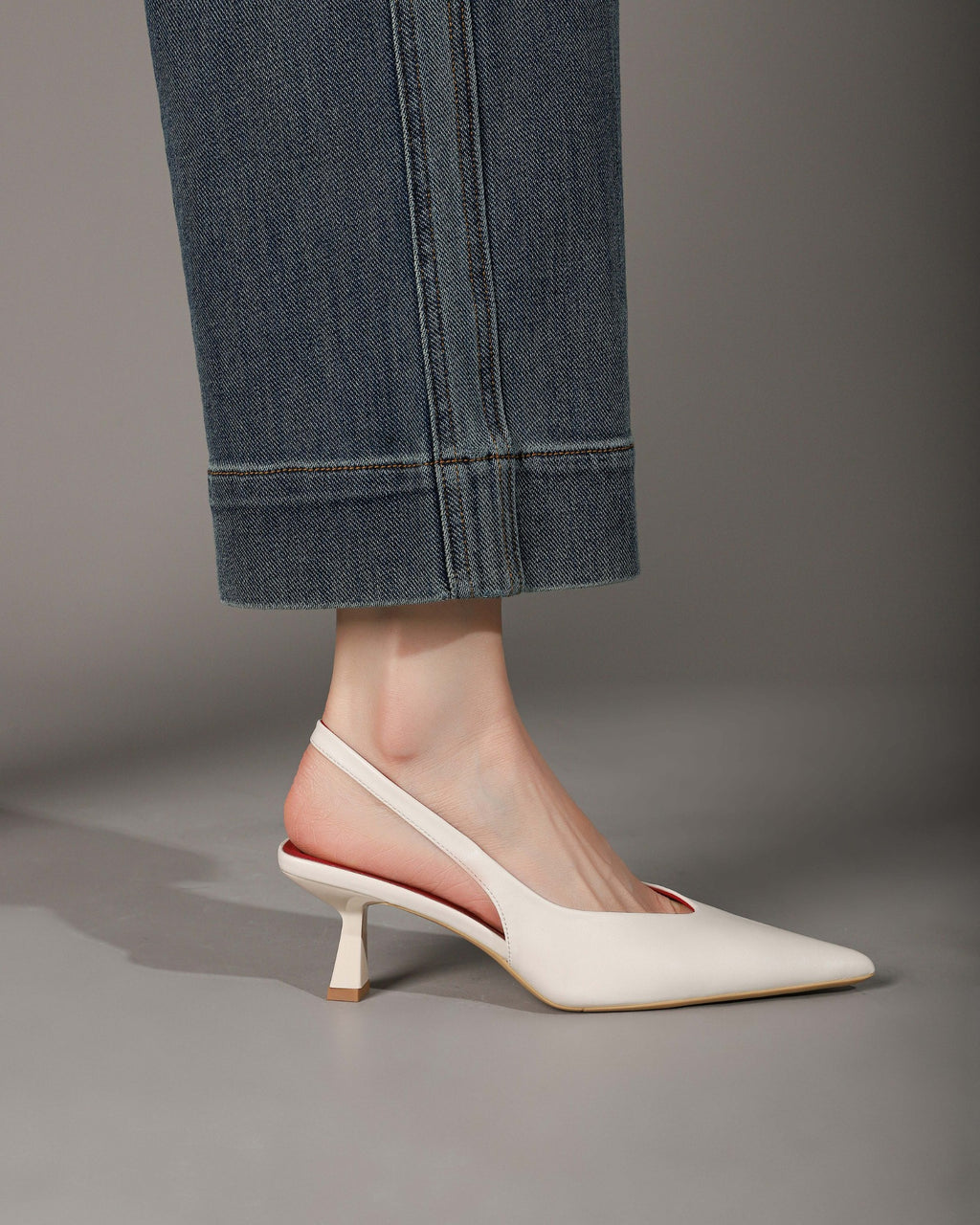 Off-white pointed-toe slingback heel modeled side profile