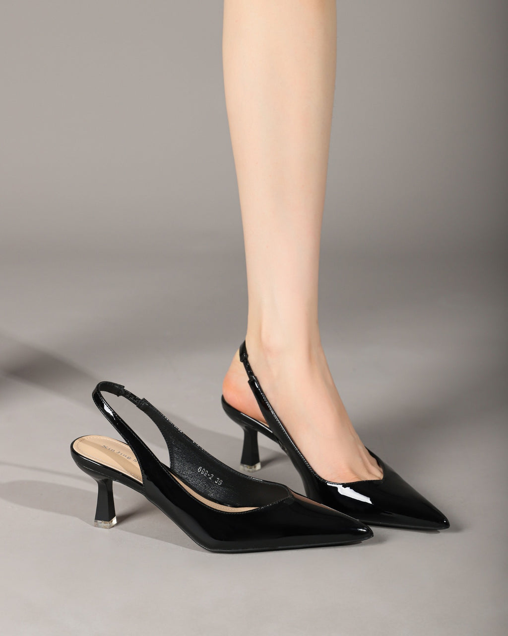 Black patent slingback heels on model