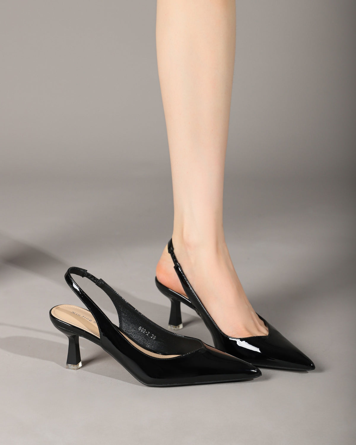Black patent slingback heels on model