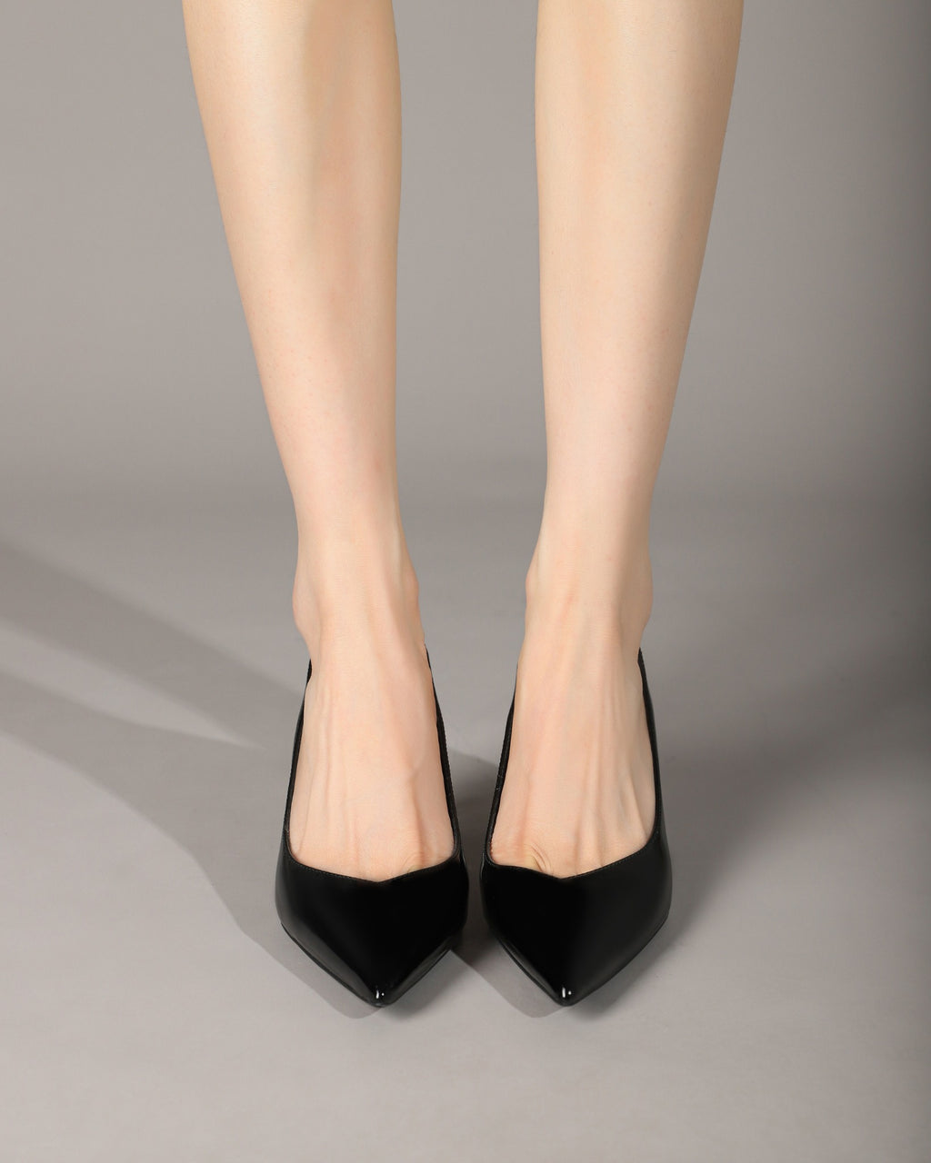 Black pointed-toe slingback heels styled on model