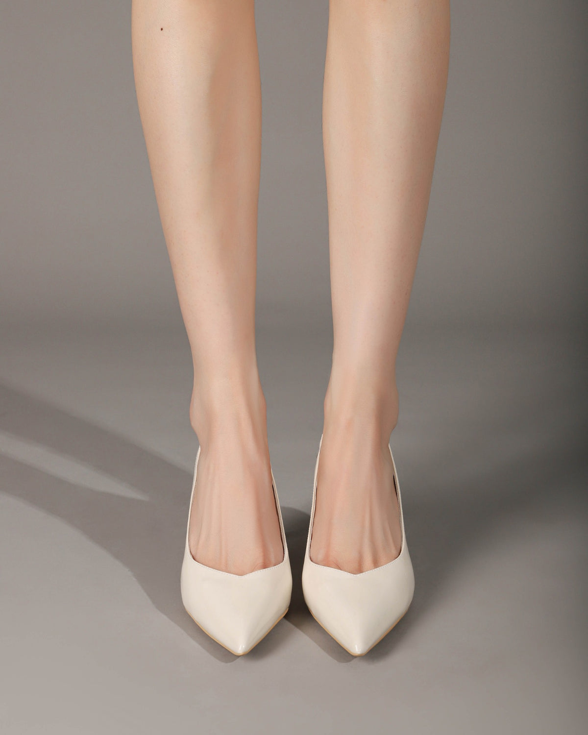 Cream pointed-toe slingback heels styled on model