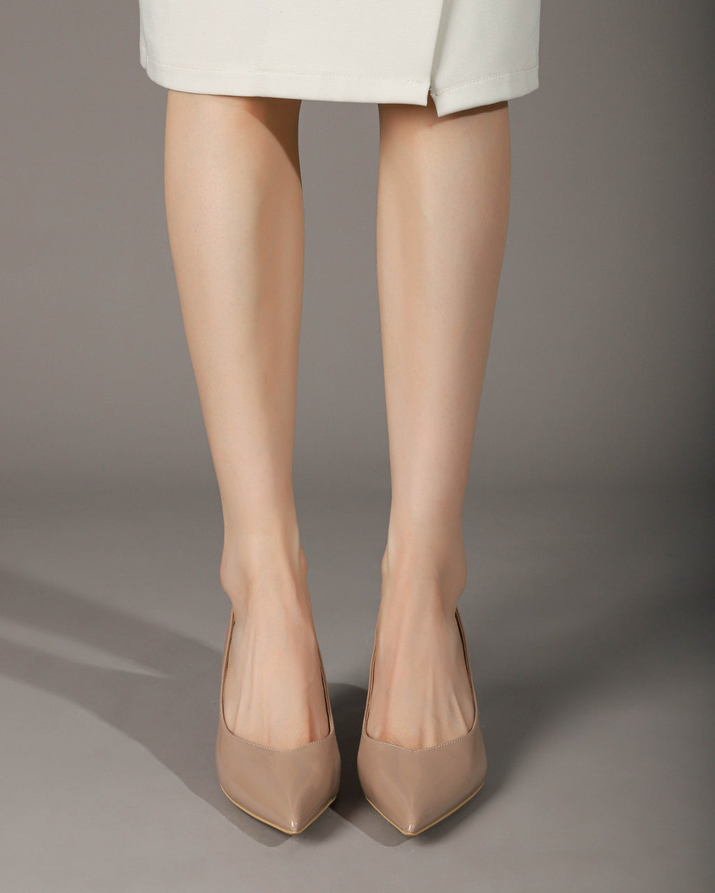 Khaki pointed-toe slingback heels on model front angle
