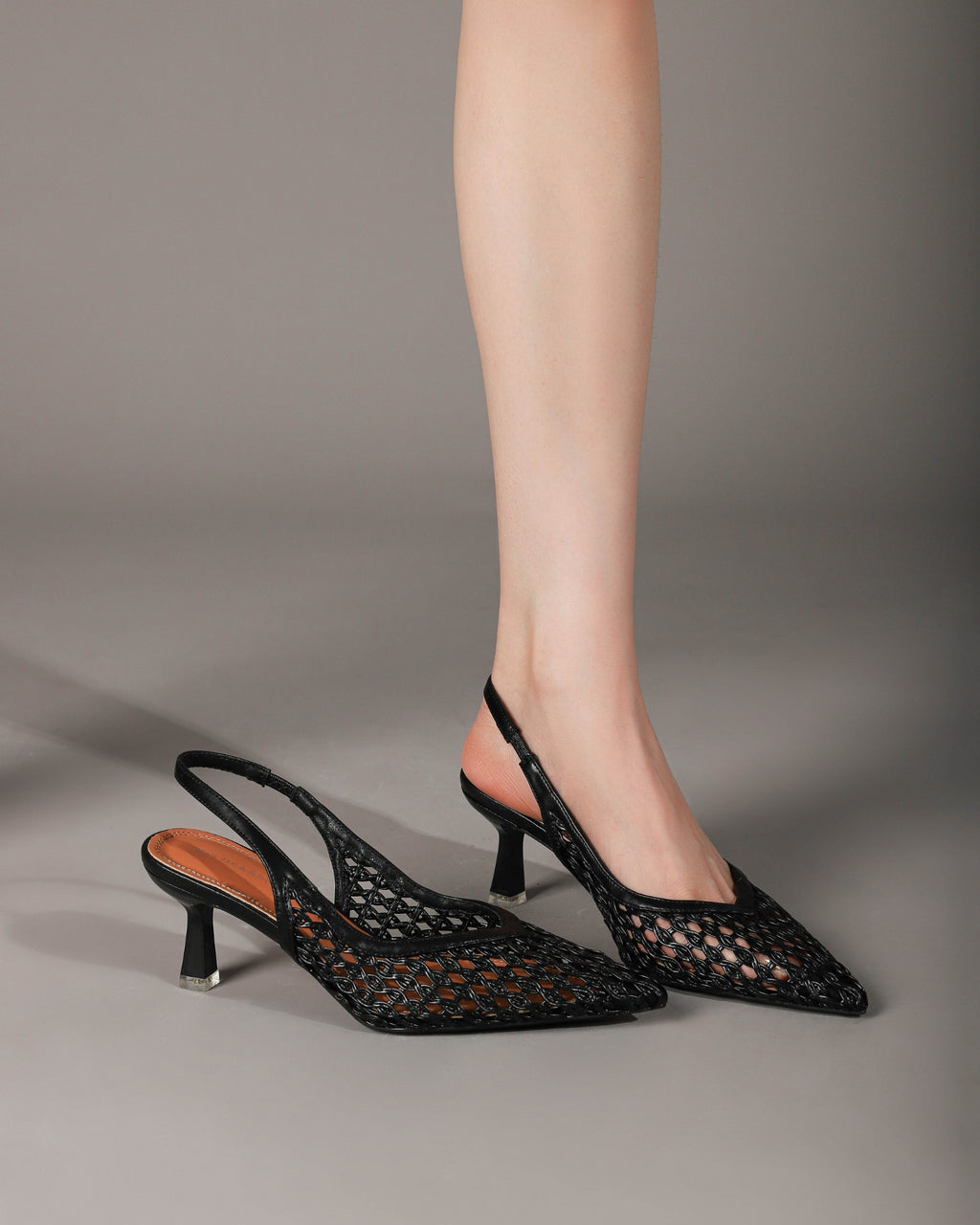 Black woven slingback heels worn crossed legs side view