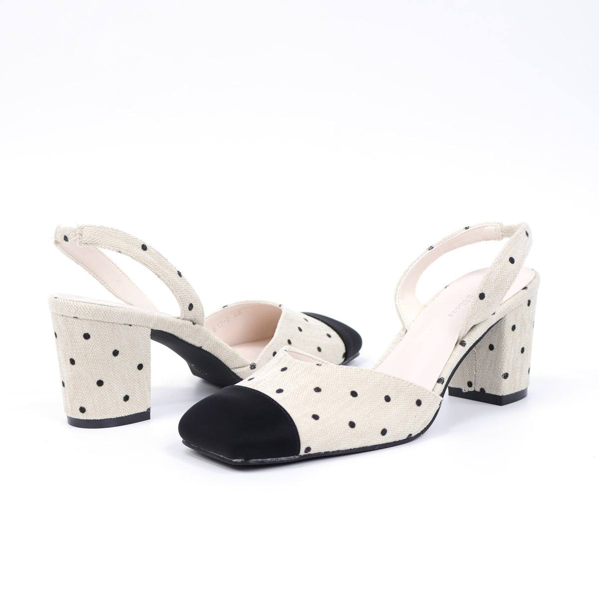 Off-white polka-dot slingback heels pair rear angle